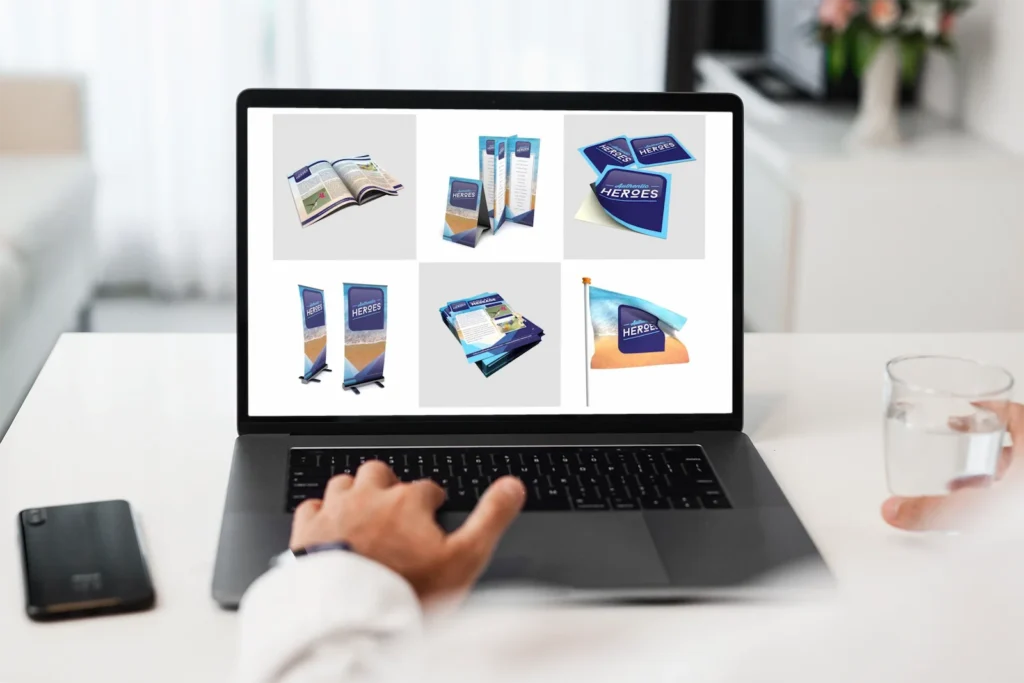 Persoon bekijkt op een laptop een assortiment drukwerk- en promotieproducten in één huisstijl